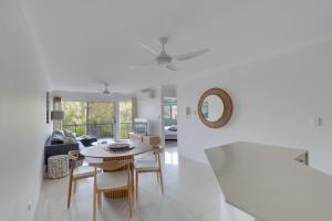 a white living room with a table and chairs at 2 BR Coastal Bliss Opposite Currumbin Beach in Gold Coast