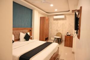 una camera da letto con un letto e una TV a schermo piatto di Riddhi Palace a Lucknow
