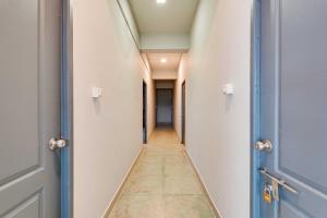 a corridor of an empty hallway with two doors at Collection O ECR Stays Near Nemmeli Beach in Chennai