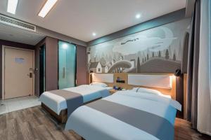 une chambre avec deux lits et un tableau au mur dans l'établissement Thank Inn Hotel Zhejiang Ningbo Haishu Yinzhou Avenue Metro Station, à Ningbo 207 autres photos