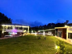 a building with lights in a field at night at Glenvista Estate in Panchgani +6 photos