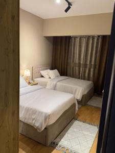una camera da letto con due letti e una finestra di كمبوند روضة زايد قلب الشيخ زايد a Sheikh Zayed