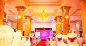 a banquet hall with white chairs and a purple screen at A1 Hotel - Dien Bien Phu in Diện Biên Phủ