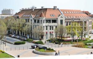 a large building with people walking in front of it at Balian apartman in Siófok