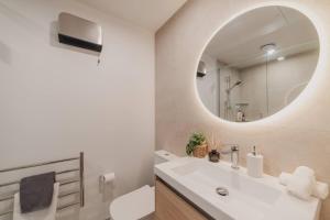un baño con lavabo y espejo en Central 1BR Apartment with Kitchen & Patio, en Christchurch