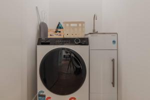 Una lavadora y un frigorífico en una habitación. en Central 1BR Apartment with Kitchen & Patio, en Christchurch