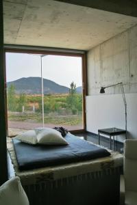 a large bed in a room with a large window at Centro de Agroecologia y Medio Ambiente de Murcia in Bullas
