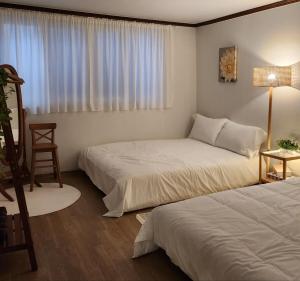 スウォンにあるHanggung Tteul Anaeのベッドが2つと窓があるホテルの部屋