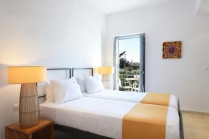 a bedroom with a bed with a lamp and a window at Orloff Resort in Spetses