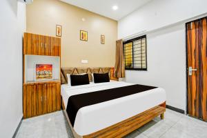 a bedroom with a large bed and a window at Hotel O katyayani in Indore