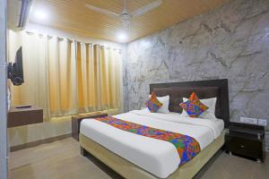a bedroom with a large bed and a stone wall at Via Geras - Nehru Place Market in New Delhi