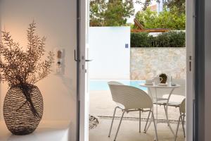 a room with a table and chairs and a vase at Orloff Resort in Spetses