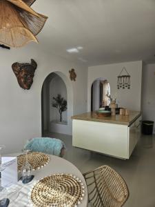 a dining room with a table and chairs and a counter at Casa la Baouzza in Cumbre del Sol