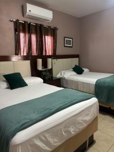 a hotel room with two beds with green sheets at Hotel Lima Park in La Lima