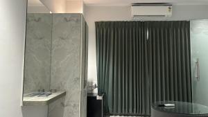 a bathroom with a shower with a green curtain at Hotel SERENE PRAIA in Visakhapatnam