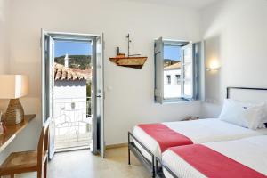 a bedroom with two beds and a balcony at Orloff Resort in Spetses