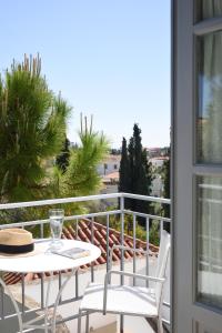 a patio with a table and chairs on a balcony at Orloff Resort in Spetses
