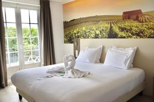 a hotel room with a bed with a swan on it at Best Western Hotel Restaurant Ile de France in Château-Thierry