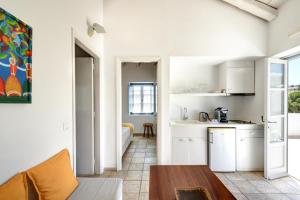 a kitchen with white cabinets and a table in a room at Orloff Resort in Spetses