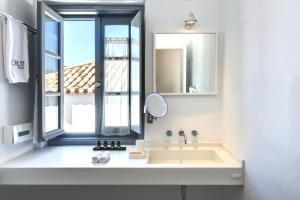 a bathroom with a sink and a mirror and a window at Orloff Resort in Spetses