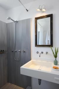 a bathroom with a sink and a mirror and a shower at Orloff Resort in Spetses