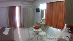 ein Wohnzimmer mit einem Glastisch und einem Bett in der Unterkunft Sirena Apartments in Agia Pelagia