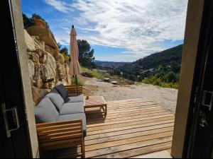 a porch with a couch and an umbrella on a beach at Appartement en rez-de-jardin in La Valette-du-Var
