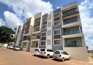 un edificio con auto parcheggiate di fronte di Spacious 3Bedroom Apartment in Muyenga, Bukasa Road a Kampala