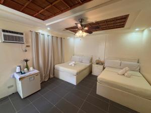 a room with two beds and a ceiling fan at Seabird International Resort in Boracay