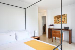 a bedroom with a bed and a desk and a chair at Orloff Resort in Spetses