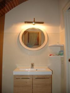 y baño con lavabo y espejo. en Monolocale a Buonconvento, en Buonconvento