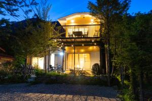 a house with a balcony at night at VillaLakeIrodori in Fujikawaguchiko