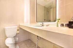a bathroom with a toilet and a sink with a mirror at Jinjiang Inn Jinhua Binhong Road in Jinhua +125 photos