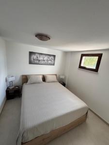 ein Schlafzimmer mit einem Bett in einem weißen Raum in der Unterkunft Giagiumar in Torre Dei Corsari