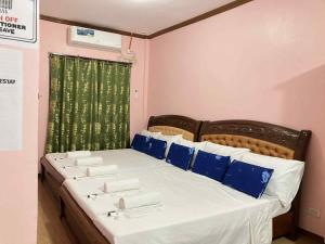 a bedroom with a bed with blue and white pillows at Sandingan Homestay in Loon