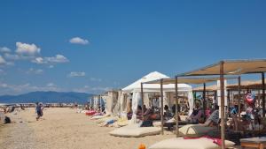 a group of people sitting on a beach with umbrellas at Agia Lydia Sea View Suite House in Karianí