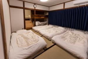 three mattresses in a room with white blankets at VillaLakeIrodori in Fujikawaguchiko