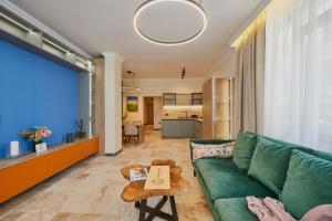 a living room with a green couch and a table at Florance Rentals Luxury Apartments in Nessebar in Nesebar