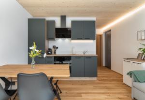 una cucina e una sala da pranzo con tavolo e sedie in legno di KopfRausch Appartements a Feldkirch