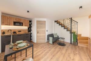 a kitchen and living room with a table and a staircase at Naša hiša in Bohinj