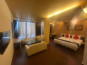 a hotel room with a bed and a desk and a room at Hotel Apex Intercontinental in Jaipur