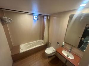 a bathroom with a tub and a toilet and a sink at Hotel Apex Intercontinental in Jaipur