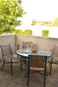 a patio table and chairs with a table and glasses at Appartement 4 pers MAS DES ARENES in Mouriès