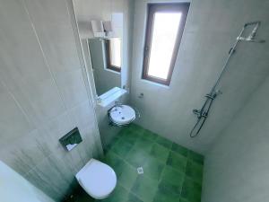 a bathroom with a toilet and a shower and a sink at Family hotel Delfa in Chernomorets +26 photos