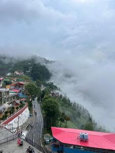 una montaña con un camino en una colina con casas en M S guest house dhanolti, en Dhanaulti
