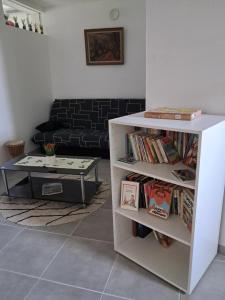 a living room with a book shelf and a coffee table at BRS Appartment in Le Grand-Lucé