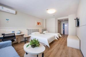 une chambre d'hôtel avec quatre lits et un canapé dans l'établissement JinJiang Inn Baoji Administra Tion Center, à Baoji 195 autres photos