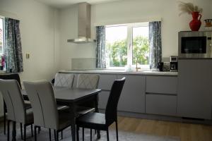 a kitchen and dining room with a table and chairs at Koetshuis in Nes