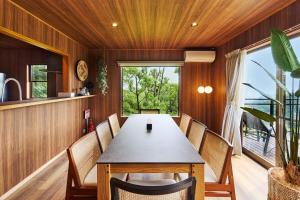 a dining room with a table and chairs and a window at マイグレChillax in Higashiizu +12 photos