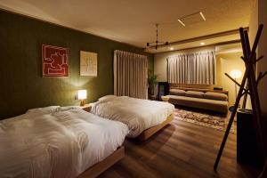 a hotel room with two beds and a couch at マイグレChillax in Higashiizu